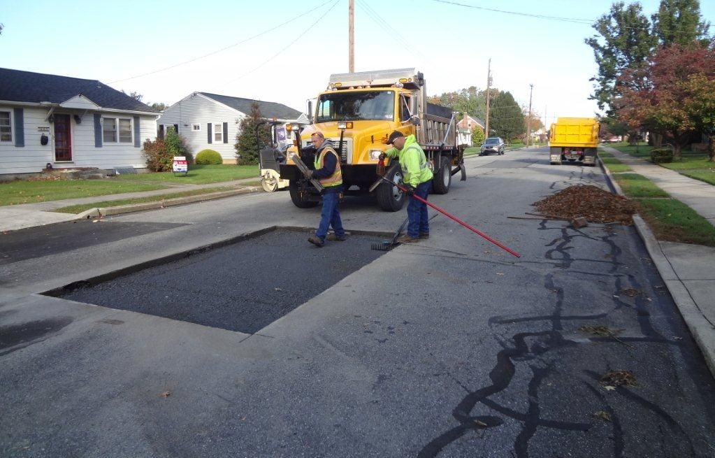 Construction crew sealing and patching a road